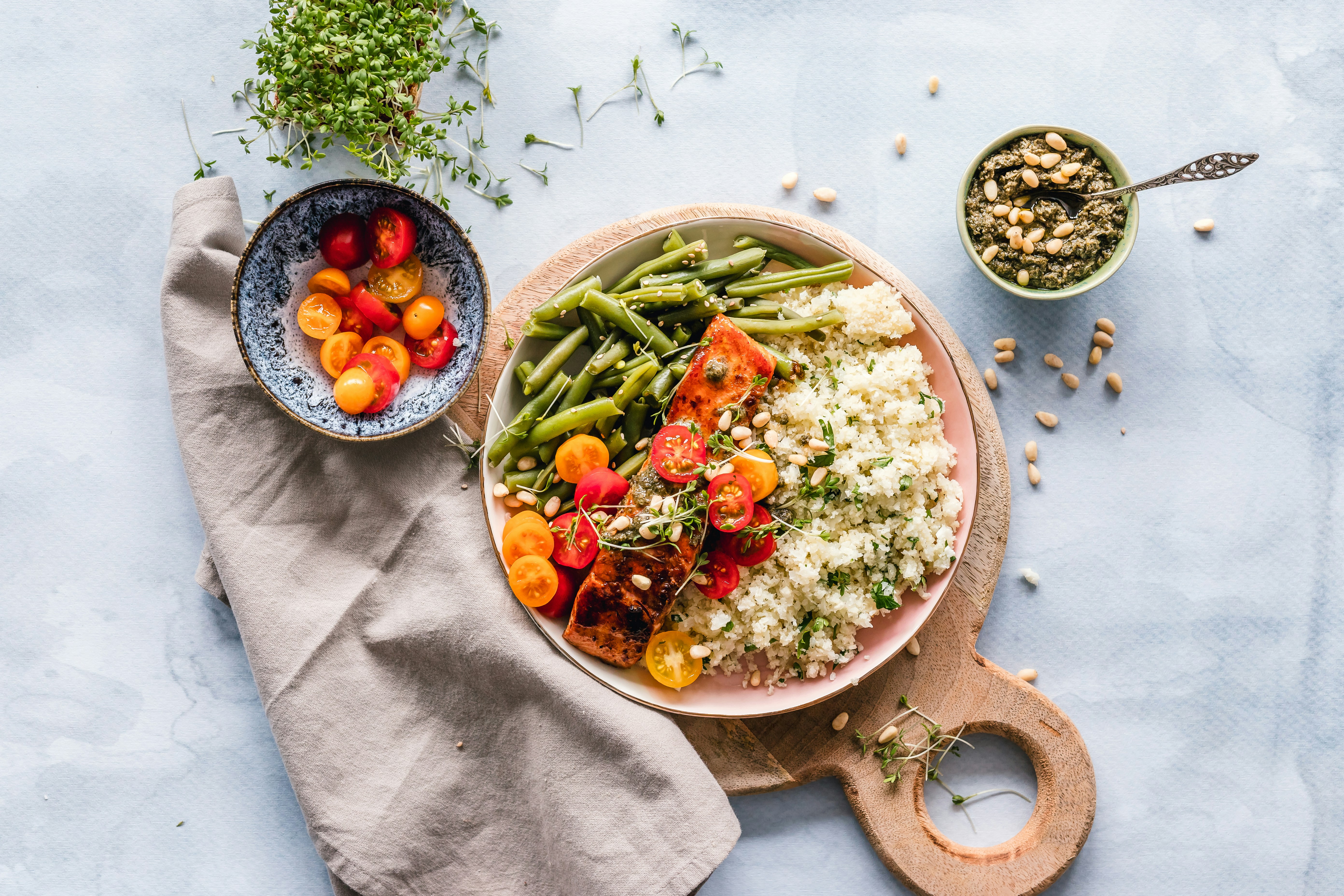 A balanced bowl of salmon, cauliflower couscous, green beans and fresh tomatoes